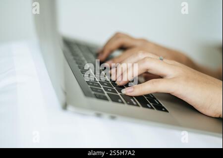 A Womans hand that is placed on a laptop. Selective focus. Stock Photo