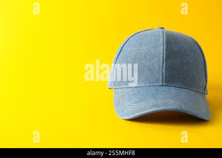 Stylish denim baseball cap on yellow background. Mockup for design Stock Photo