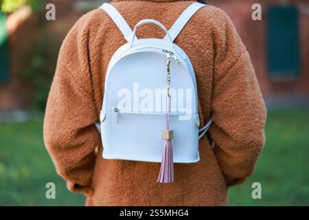 Woman with pink leather keychain on her backpack outdoors, closeup Stock Photo