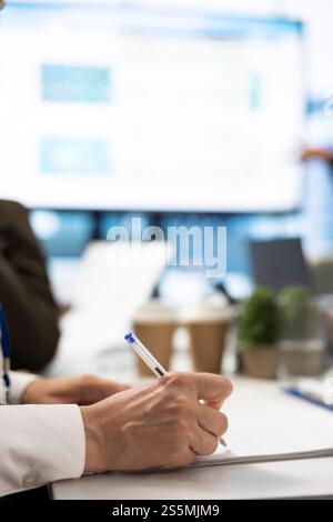 Financial consultant takes notes during a project briefing meeting, working on allocating available resources to meet the business objectives. Expert making future projections. Close up. Stock Photo