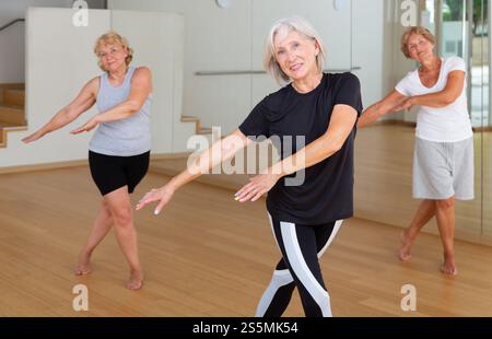 Active mature woman learning dynamic dances in choreography class Stock Photo