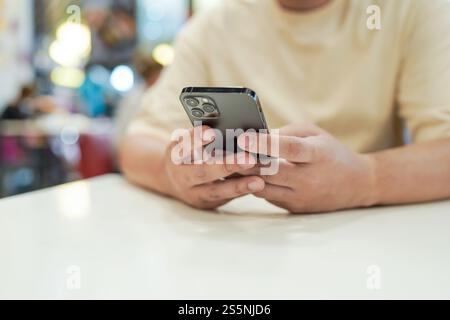 Relaxed young asian man using smart phone spending time checking news social media Stock Photo