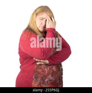 A middle-aged woman appears deep in thought, resting her head in her hand. Stock Photo