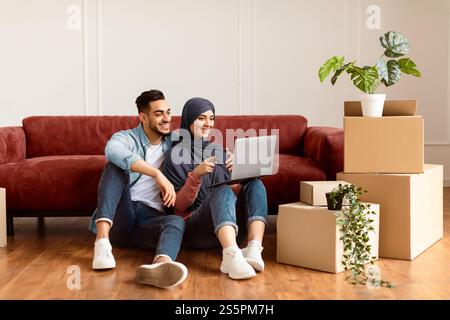 Happy man and woman using laptop after relocation Stock Photo
