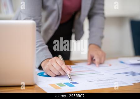 Businesswoman Accountant analyzing investment charts Invoice and pressing calculator buttons over documents. Accounting Bookkeeper Clerk Bank Advisor Stock Photo