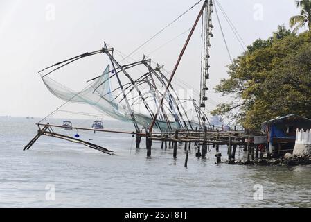 Fort Kochi, Kochi, Kerala, South India, India, Asia, Chinese fishing facilities on the waterfront with boats in the background, Asia Stock Photo