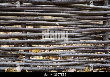 Decorative fence from wooden branches. Rare wooden wall Handmade small wooden thin branches in Ukrainian western style. Decorative wooden fence Stock Photo