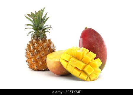 A close-up view of a ripe pineapple and whole mango, alongside a half mango with diced cubes on a white background, showcasing their vibrant appeal an Stock Photo
