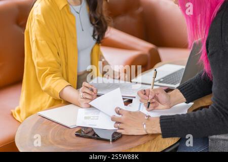 LGBTQ+ transgender man Beautiful Authentic Specialist with Pink Hair and Non-binary trans working together Working Design in creative workplace team Stock Photo