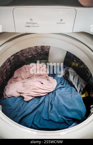 Heap of laundry inside of top loading washing machine Stock Photo