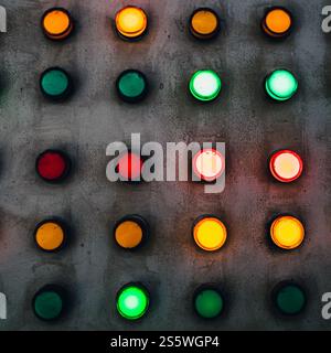 Array of red, green and yellow industrial signal lamp indicators on old and rustic electrical power control center panel Stock Photo
