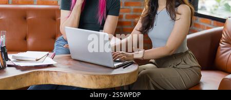 LGBTQ+ transgender man Beautiful Authentic Specialist with Pink Hair and Non-binary trans working together Working Design in creative workplace team Stock Photo