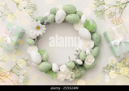 Easter wreath, flowers and gifts on light background Stock Photo
