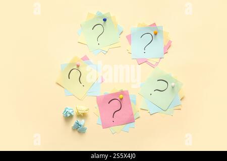 Different sticky notes with question marks pinned on color background Stock Photo