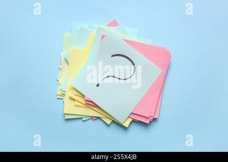 Heap of different sticky notes with question mark on color background Stock Photo