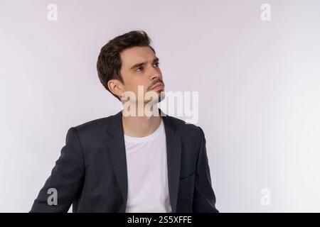Portrait of thinking man surrounded by question mark on isolated background. Finding inspiration or solution to problem. Stock Photo