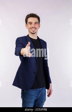 Portrait of smiling handsome businessman extend hand for handshake, look friendly, greet you, hi gesture, standing over white background Stock Photo