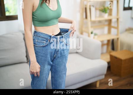 Asian woman dieting Weight loss. Slim woman in oversize jeans . Stock Photo