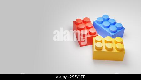 Three different colored lego blocks on a white background. The colors are red, yellow, and blue Stock Photo