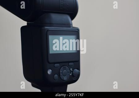 External photographic speedlight gun is mounted on the multichannel sync trigger set on a tripod. lighting equipment for studio photography. Set of Stock Photo