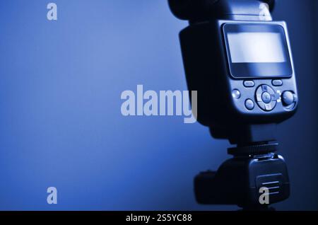 External photographic flash is mounted on the synchronizer, which stands on a tripod. lighting equipment objects. Set of professional studio Stock Photo