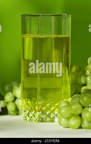 Yellow grape juice and wet bunches of green grapes Stock Photo - Alamy