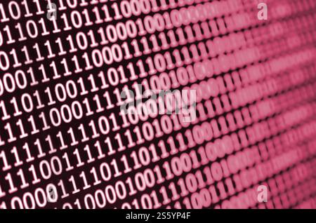 Macro shot of binary code on the monitor of an office computer. The concept of the programmers work. The flow of digital information strings. Image Stock Photo