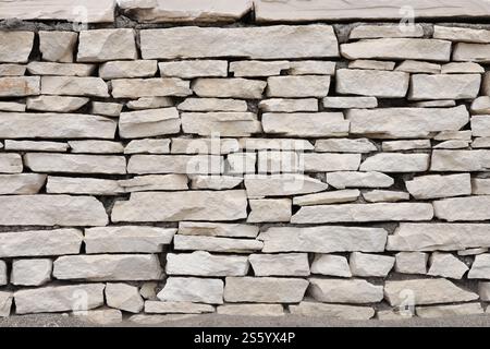 Texture of a stone wall background. Part of a stone fortress or castle fencing for background. Texture of a stone wall background from small stones Stock Photo