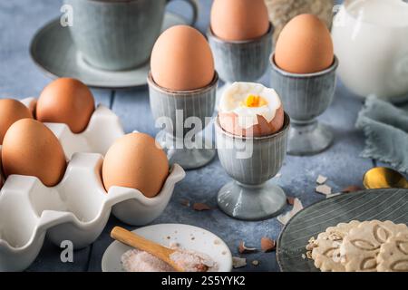 Breakfast with boiled eggs, cup of tea, milk and oat cookies Stock Photo