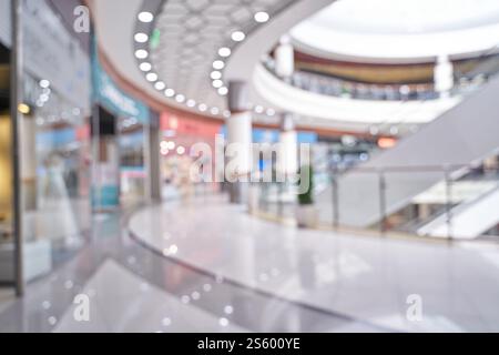 Modern shopping mall interior with blurred storefronts and elegant architecture. Stock Photo