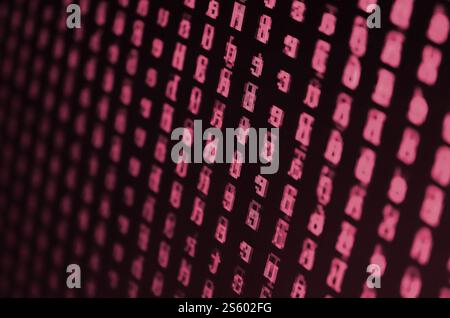 Macro shot of a glitch on the monitor of an office computer. The concept of introducing a virus. Stream of random green symbols. Image toned in Viva Stock Photo