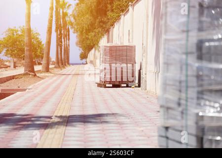 Paving stones on wooden pallet on the street sidewalk. Construction Paving of city streets and adjoining territories. Outdoor tile concrete paving Stock Photo