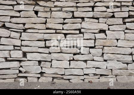 Texture of a stone wall background. Part of a stone fortress or castle fencing for background. Texture of a stone wall background from small stones Stock Photo