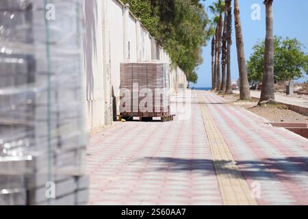 Paving stones on wooden pallet on the street sidewalk. Construction Paving of city streets and adjoining territories. Outdoor tile concrete paving Stock Photo