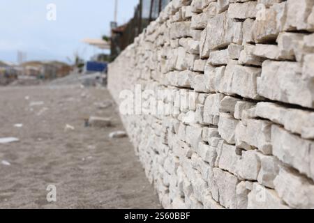 Texture of a stone wall background. Part of a stone fortress or castle fencing for background. Texture of a stone wall background from small stones Stock Photo