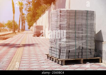 Paving stones on wooden pallet on the street sidewalk. Construction Paving of city streets and adjoining territories. Outdoor tile concrete paving Stock Photo