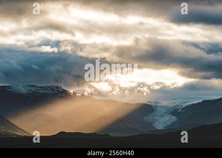 Sun rays breaking through clouds over Hoffellsjökull glacier in South Iceland. Stock Photo