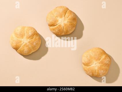 freshly baked bread buns on beige background, top view Stock Photo