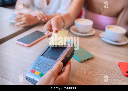 Woman Making Contactless Payment with Credit Card in a Cafe Stock Photo
