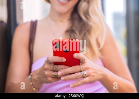 Unrecognizable Blonde Woman Using Smartphone Outdoors in Urban Setting Stock Photo