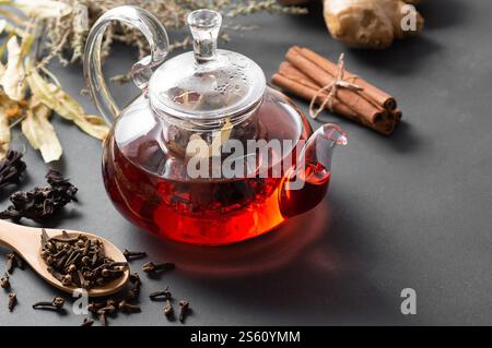 Winter herbs and spices tea in glass teapot or mug, alternative medicine for the immune system, herbal hot drink concept Stock Photo