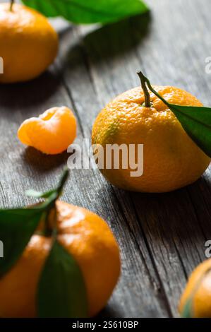 Fresh ripe juicy yellow mandarin ( clementine, tangerine ) on rustic vintage table with leaf. Winter fruit background concept Stock Photo