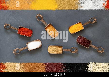 Various spices in spoon or bowl on dark rustic table, spice background Stock Photo