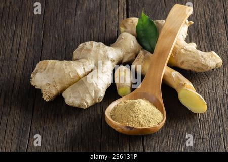 Fresh chopped ginger root and ground ginger powder in wooden spoon on wooden rustic table. Healthy food, spice. Zingiber officinale Stock Photo