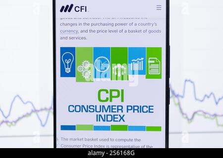 A smartphone displaying information about the Consumer Price Index CPI with a stock market graph in the background. On CFI website Stock Photo