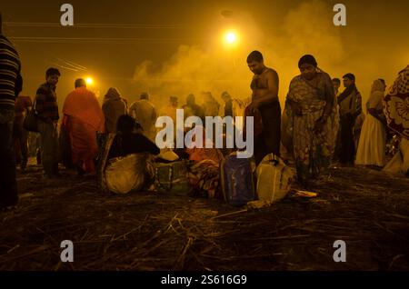 Crowd gathered at night market during festival with smoke and bright street lights Stock Photo