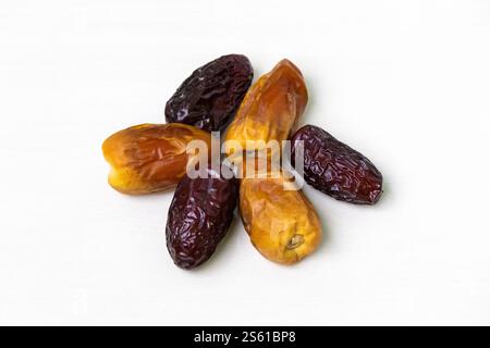 Two varieties of fresh, tasty, and delicious dried date palm fruits are isolated on a white background. Stock Photo