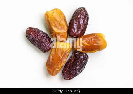 Two varieties of fresh, tasty, and delicious dried date palm fruits are isolated on a white background. Top view. Stock Photo