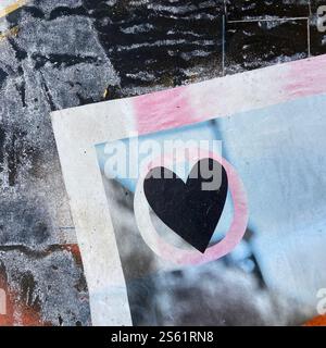 A close-up of an artistic piece with a black heart inside a circular shape, set against a grunge textured background with contrasting colors. Stock Photo