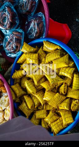 Plastic Wrapped Rice Cake Traditional rice cakes wrapped in coconut leaves at a market in ...